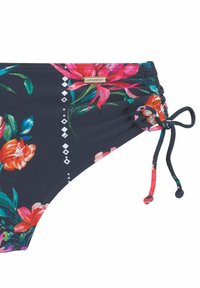 Bas de bikini fleuri en bleu marine avec des fleurs roses et orange. Présente un côté froncé et un lien ajustable. Logo de la marque affiché sur le matériel.