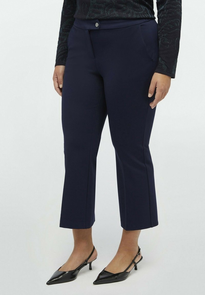 Marinblå beskurna byxor med skräddarsydd passform, med en slät front, sidofickor och en enkel knappstängning. Slät tygtextur.