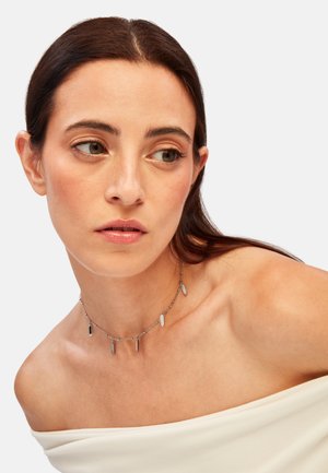Collana d'argento con pendenti allungati e piatti su una sottile catena. I pendenti variano nella forma e sono equidistanti lungo la catena.