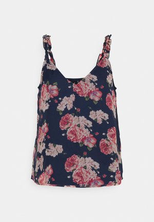 Top de tanque floral azul-marinho com alças em babado, apresentando grandes rosas cor-de-rosa e brancas em um tecido macio. Design em V com fendas laterais.