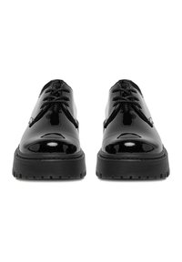 Mustad läikiva lakknahaga kingad, millel on paks must kummist tald, ümar nina ja klassikaline paeltega kinnihoidev disain. Sile läikiv pind ja tekstuuriga tald.