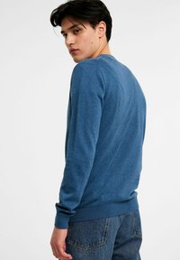 Blauer Pullover aus weichem Stoff, mit Rundhalsausschnitt, gerippten Bündchen und Saum. Das Design hat eine glatte Textur und eine lockere Passform.