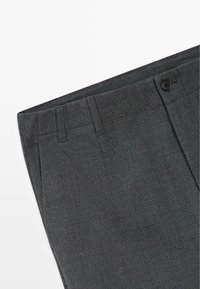 Pantaloni su misura grigio scuro con passanti per cintura, chiusura con bottone e tasca frontale su sfondo bianco.