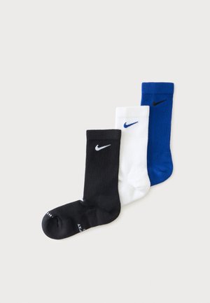 Τρεις κάλτσες Nike σε μαύρο, λευκό και μπλε, κάθε μία με το αντιθετικό λογότυπο Nike Swoosh στον αστράγαλο.