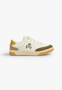 Weißer Sneaker mit beigen und olivgrünen Akzenten, ausgestattet mit einem Design von Totenkopf und gekreuzten Knochen, strukturiertem Wildleder und einer Gummisohle.