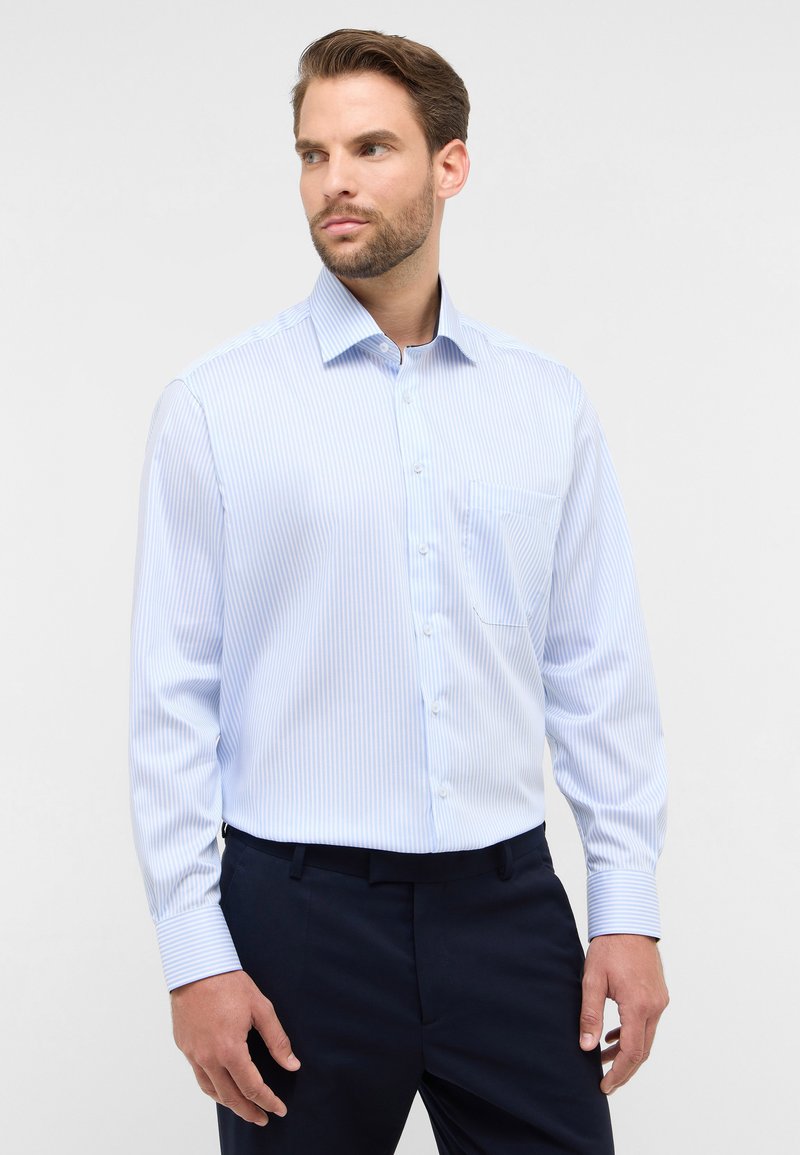 Camicia a righe blu chiaro con colletto, apertura con bottoni e taschino sul petto. Tessuto morbido con maniche lunghe.