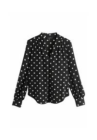 Fekete blúz fehér pöttyökkel, V-nyakú, hosszú fodros ujjakkal és ívelt szegéllyel. Sima anyagból készült.