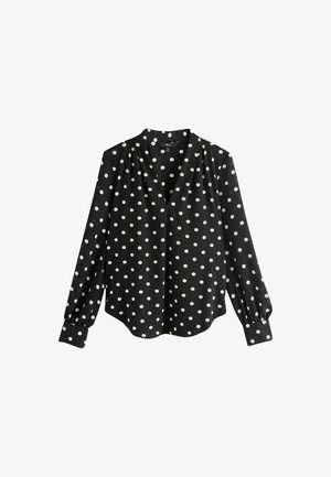 Czarna bluzka w białe grochy, z dekoltem w serek, długimi bufiastymi rękawami oraz zaokrąglonym dołem. Wykonana z gładkiego materiału.