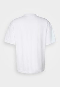 Balts kokvilnas T-kreklis ar īsām piedurknēm, apaļu kakla izgriezumu un brīvu piegriezumu. Mugura ir vienkārša, bez jebkādām grafikām vai rakstiem.