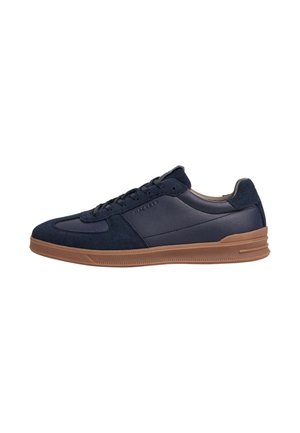 Lage sneaker in marineblauw met suède en leren panelen, bruine rubberen zool en veters aan de voorkant.