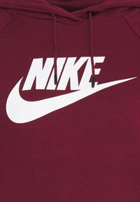 Maroon hoodie with white Nike logo and swoosh on the chest, featuring matching drawstrings with black tips.