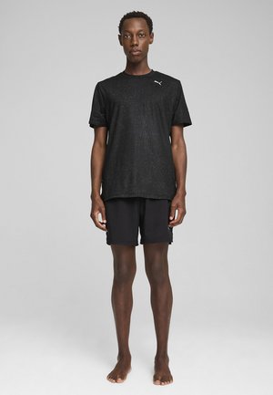Black athletic t-shirt with a textured pattern, short sleeves, and PUMA logo. Paired with black shorts, both made of lightweight fabric.