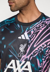 Sort sportstrøje med et grafisk mønster i pink og turkis, med Adidas-logo, Liverpool FC-emblem og teksten "AXA" i hvid.