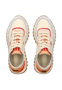 Creme- und graue Sneaker mit roten Akzenten und einer strukturierten orangen Ferse. Sie verfügen über beige Schnürsenkel und eine Gummisohle mit einem gemusterten Profil.