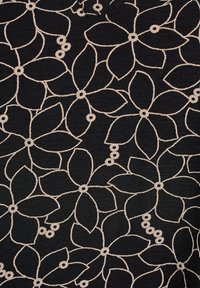Mustanvärinen kangas, jossa on kukkakuosi, jossa on beigenvärisiä ääriviivoja ja pyöreitä yksityiskohtia, luoden tekstuuripintaisen suunnittelun.