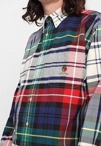 Camicia con bottoni caratterizzata da un motivo tartan multicolore nelle tonalità di rosso, verde, blu e grigio, con taschino sul petto e logo ricamato.