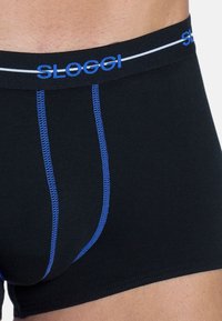Schwarze Herren-Boxershorts mit blauer Naht, ausgestattet mit einem Logo-Bund und einem eng anliegenden Design. Das weiche, dehnbare Material sorgt für Komfort.