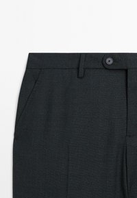 Dunkelgraue, maßgeschneiderte Hose mit dezentem Karomuster, ausgestattet mit schrägen Taschen und einem Knopfverschluss an der Taille.