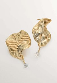 Pendientes en tono dorado con un diseño ondulado y texturizado, con estrías en capas y gotas de cristal transparente en la parte inferior.