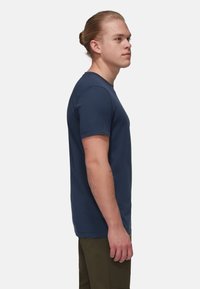 Marineblå bomulds t-shirt med korte ærmer, rund halsudskæring og ensfarvet design. Har synlig syning og en afslappet pasform.