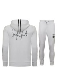 Witte hoodie en broek set met een zwart logo op de achterkant, zwarte zijstrepen en een elastische tailleband met drawstring. Slim-fit ontwerp.