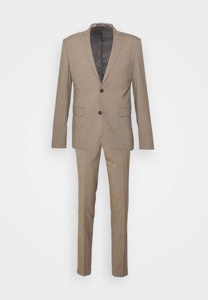 Tan tailored suit featuring a single-breasted jacket with two buttons, notch lapels, and flat-front trousers with a smooth finish.