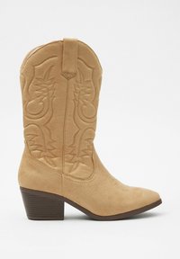 Botas de cowboy de ante marrón con detalle bordado, punta afilada y tacón bajo apilado. Incluyen una lengüeta para facilitar el uso.