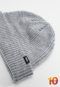 Szary dzianinowy beanie o ryflowanej fakturze, z podwinięciem i czarną metką logo Vans. Miękka tkanina z wyraźnym, równomiernym wzorem.