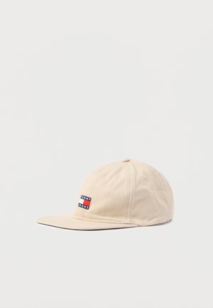 Beige cotton baseball cap with a stitched Tommy Jeans logo patch in red, white, and blue on the front panel. Rounded crown and flat brim.