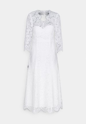 Λευκό φόρεμα από δαντέλα με τρία τέταρτα μανίκια, περίτεχνα λουλουδάτα μοτίβα, εφαρμοστό κορσέ και φουντωτή φούστα με καμπυλωτή εσοχή.