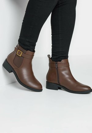 Bruine synthetische enkellaarzen met een gladde textuur, voorzien van een zijrits, een gespsaccent en een lage blokhak.