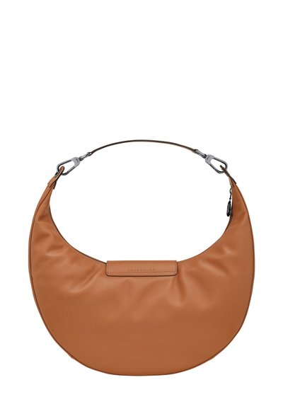 Tan crescent-shaped leather handbag with detachable shoulder strap and metal clasps, featuring a small rectangular logo patch.