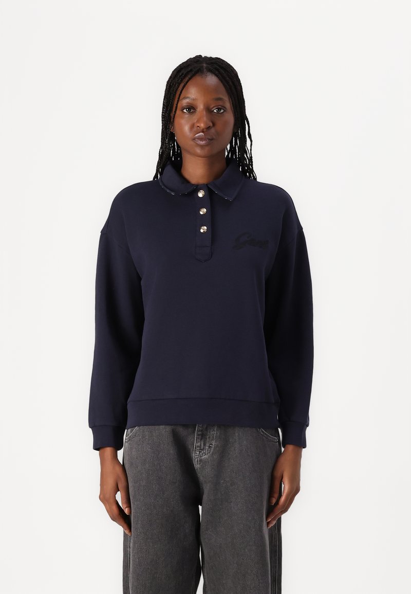 Marineblauwe pullover met een kraag en een drie knopen sluiting, met een klein geborduurd logo op de borst. Zacht materiaal en een comfortabele pasvorm.
