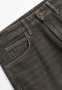 I jeans in denim scuro presentano un classico design a cinque tasche, cuciture arancioni a contrasto e una chiusura con bottone. Texture liscia con una leggera lucentezza.