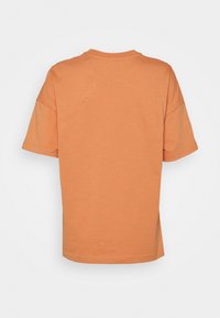 Camiseta de manga corta en un suave tejido de algodón naranja. Presenta un cuello redondo, un corte relajado y un diseño simple y limpio sin patrones.