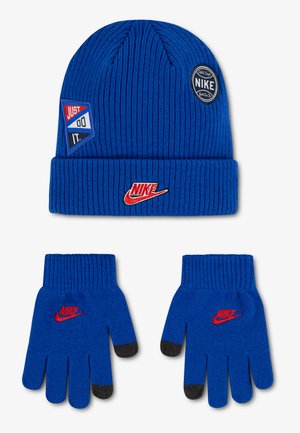 Blå strikket Nike hue med røde logoer og matchende handsker med sorte fingerspidser og røde Nike logoer.