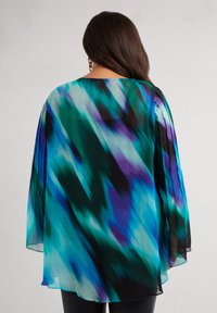 Chiffon top in blue and teal with a flowing design. Features long, semi-sheer sleeves and a round neckline. Black accents at the hem.