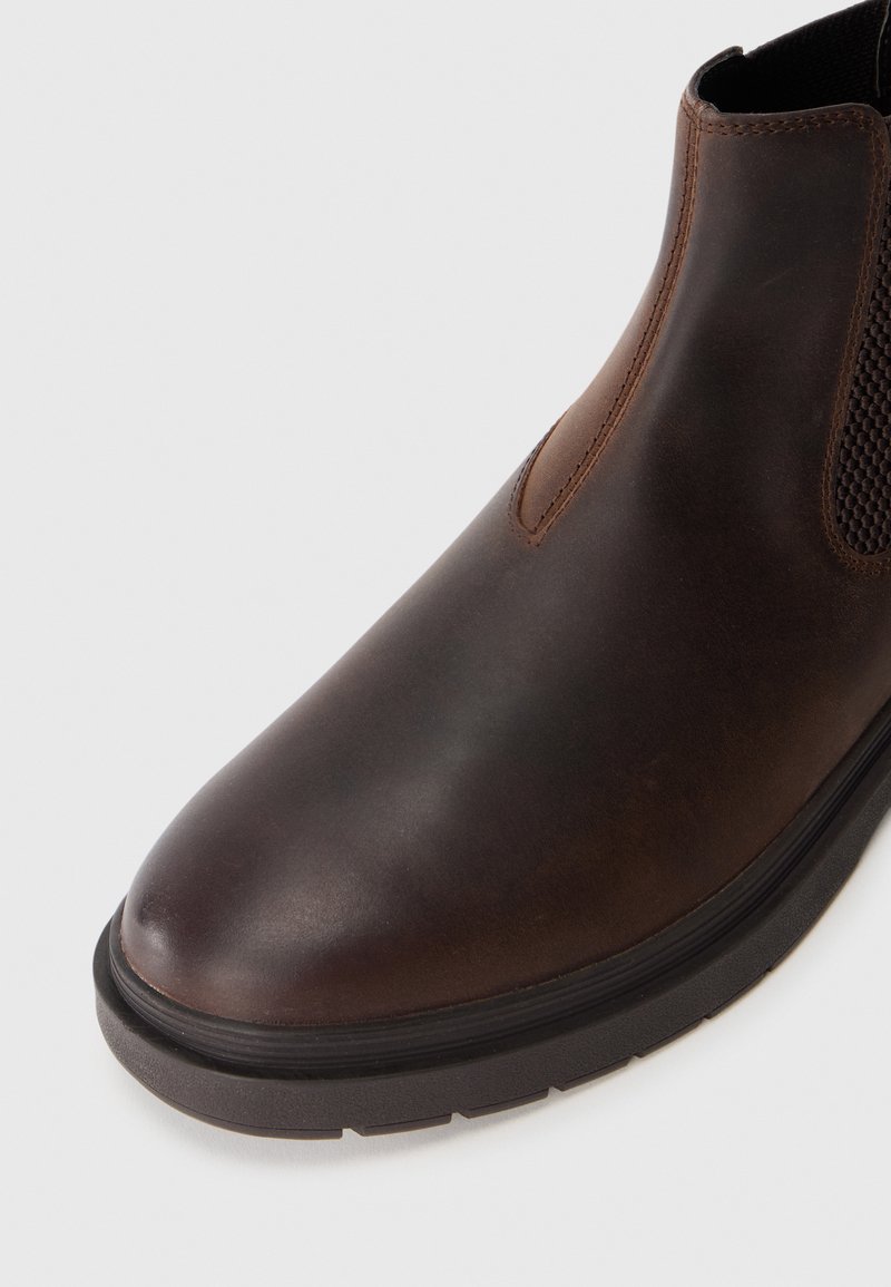 Braune Leder-Stiefelette mit abgerundeter Zehenpartie, elastischen seitlichen Einsätzen und einer strukturierten Oberfläche im Obermaterial. Gummisohle für Grip und Langlebigkeit.