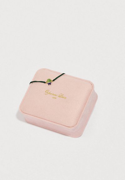 Ružová šperkovnica z plsťe so zlatou ražbou loga a zelenou stuhou na zaväzovanie, s malým ozdobným príveskom na stužke.
