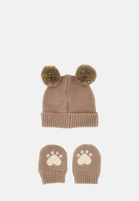 Cappello lavorato a maglia color beige con due pompon in peluche sulla parte superiore. Il set include guanti senza dita abbinati con motivi a cuore e impronta di zampa in crema.