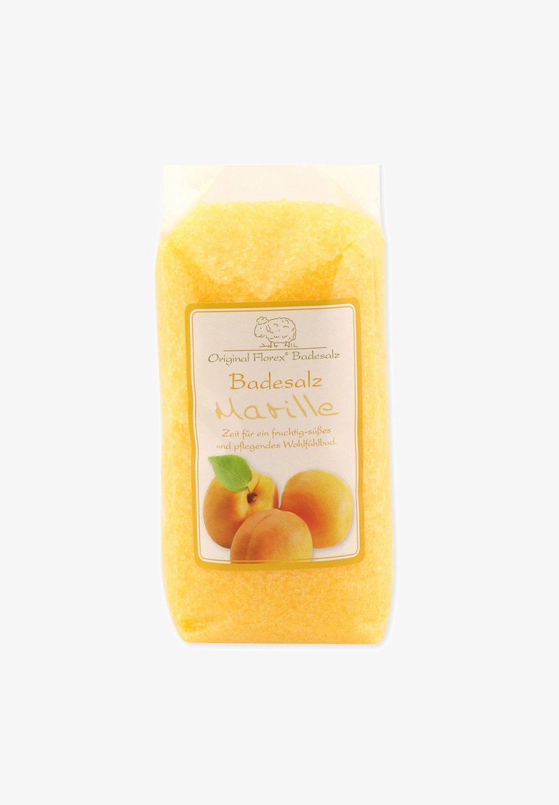 Yellow bath salt in a transparent package, featuring a label with apricot imagery and text, highlighting fruity and nurturing properties.