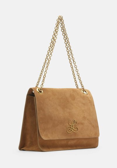 Tan suede handbag with flap closure, gold chain shoulder strap, and gold decorative logo on front flap.