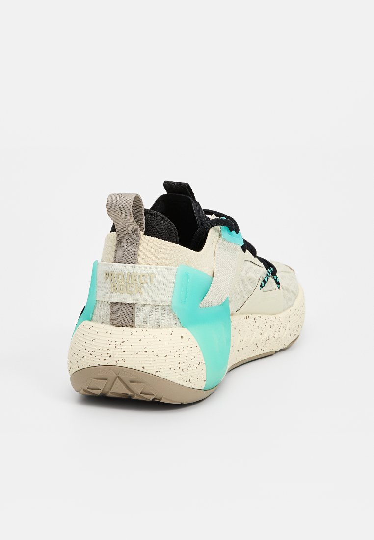 Chaussures avec une semelle beige mouchetée, une tige beige et noire texturée, et un capuchon de talon en caoutchouc turquoise. Comprend le logo "Project Rock".