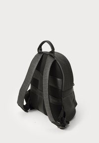 Sac à dos noir en tissu rembourré, avec des accents en maille et un logo en relief sur les bretelles. Doté de bretelles réglables et d'une poignée supérieure.