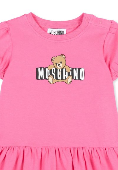 Roze babypakje met pofmouwtjes, een geplooide zoom en een teddybeer met het "MOSCHINO"-logo op de borst.