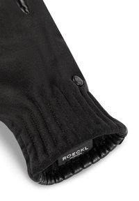 Schwarze Fleece-Handschuhe mit einem gerippten Bündchen, glatter Textur und einem runden Logo-Button. Das Innere ist mit einem weichen Stoff ausgekleidet.