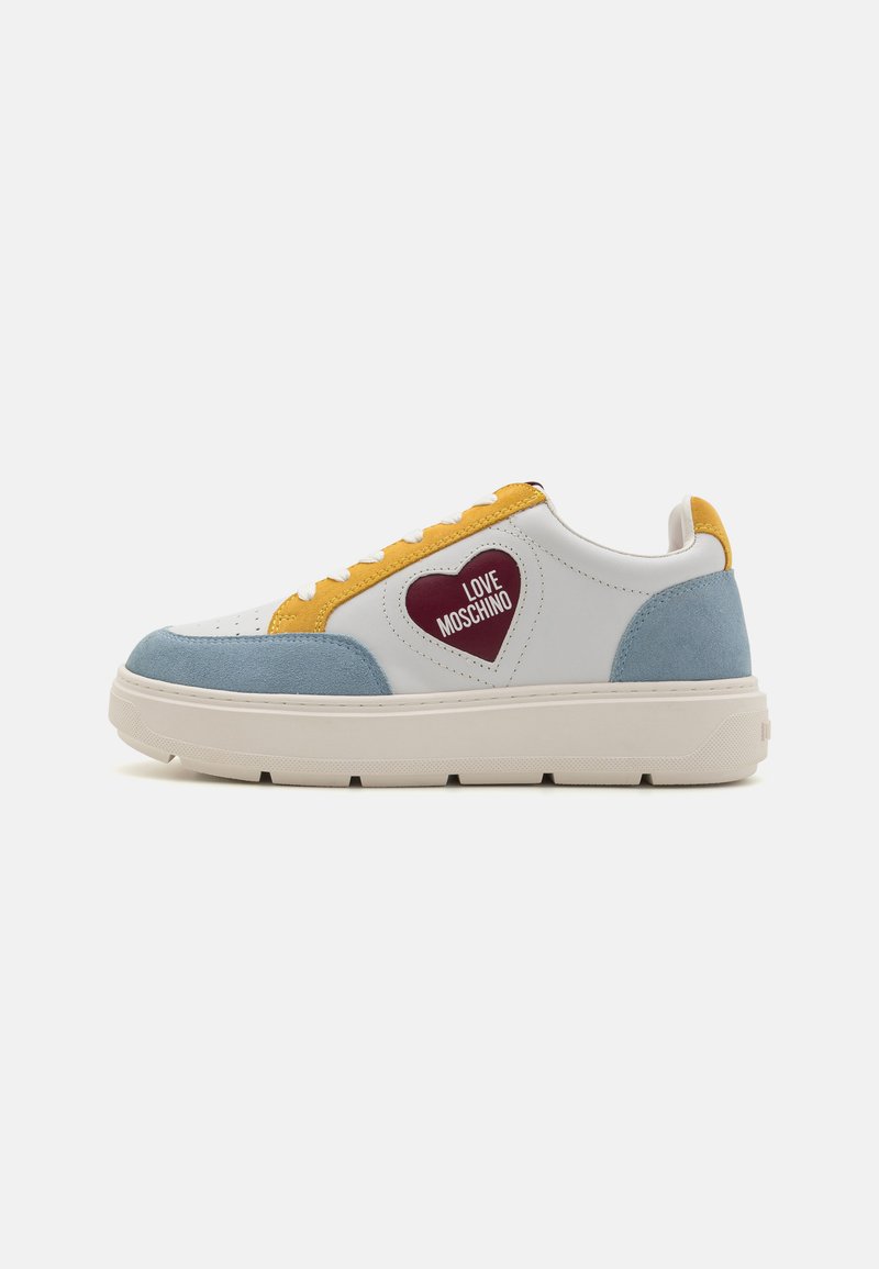 White leather sneakers with blue and yellow suede accents, featuring a red heart patch labeled "LOVE MOSCHINO" and a chunky white sole.