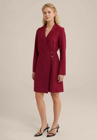 Robe portefeuille bordeaux en tissu doux, dotée de manches longues, d'une ceinture avec une boucle en argent et d'un ourlet au genou.