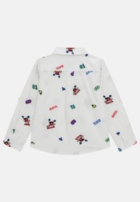 Witte blouse met lange mouwen, versierd met kleurrijke geborduurde patronen, waaronder logo's en geometrische vormen, met een klassieke kraag en knoopmanchetten.