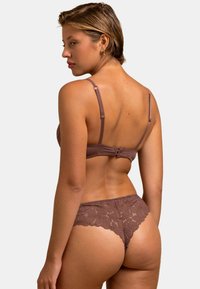 Soutien-gorge en dentelle marron et ensemble de thong assorti avec un motif floral, bretelles réglables et fermeture à crochet au dos. Tissu doux et texturé.